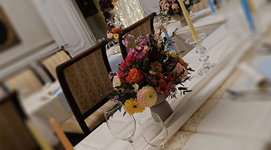 Svadobná výzdoba stola s farebnou kyticou a&nbsp;sviečkami v historickom interiéri